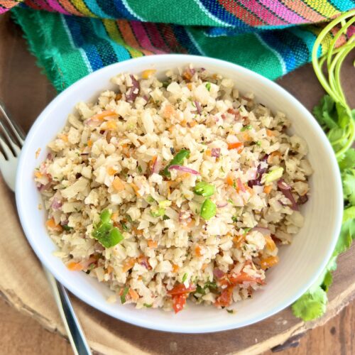 rice made with cauliflower with a fork next to the bowl