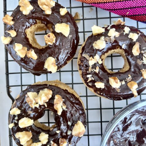 Chocolate glazed healthy gluten free donuts on a cooling rack with almonds