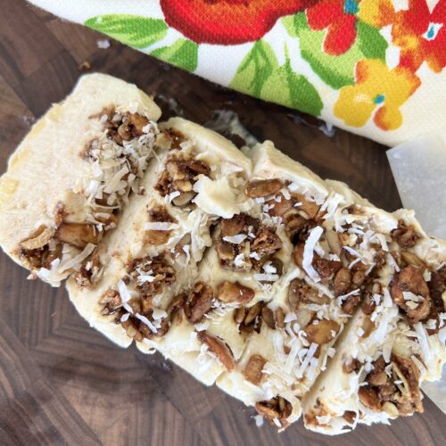 a picture of a greek yogurt frozen yogurt bar cut into pieces and set on a brown cutting board