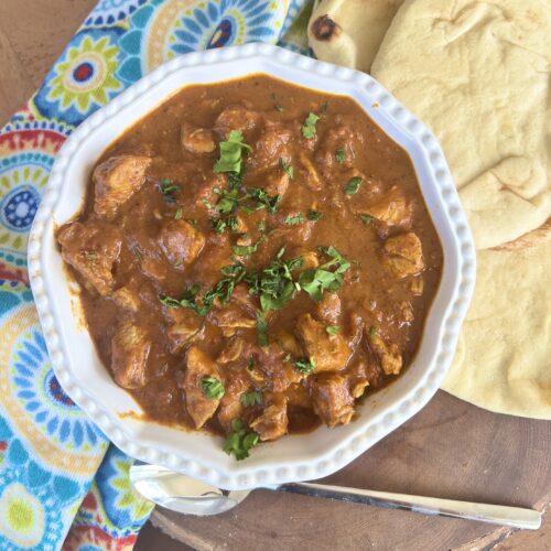 coconut curry with chicken in a bowl with naan